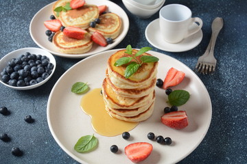Sweet pancakes served with fresh blueberries , mint, strawberries,organic agave syrup. Healthy breakfast concept