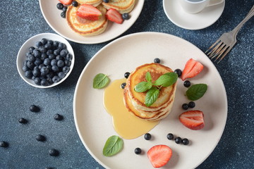 Sweet pancakes served with fresh blueberries , mint, strawberries,organic agave syrup. Healthy breakfast concept
