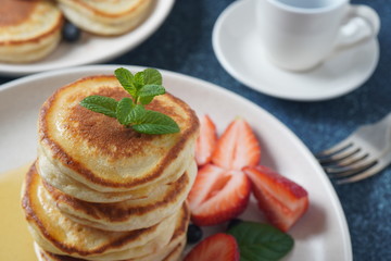 Sweet pancakes served with fresh blueberries , mint, strawberries,organic agave syrup. Healthy breakfast concept