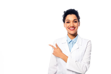 Front view of positive african american doctor looking at camera, smiling and pointing with finger...