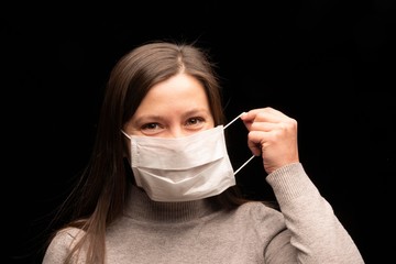 The girl wears a protective medical mask against viruses and infections and coronavirus covid 2019....