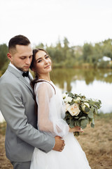 Tender wedding couple near the lake