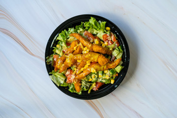 Take Away Healthy Cajun Salad with Chicken Fingers and Mustard Sauce in Black Plastic Plate Box / Package.