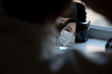 girl in protective mask against coronovirus in mirror reflection. Covid 2019.