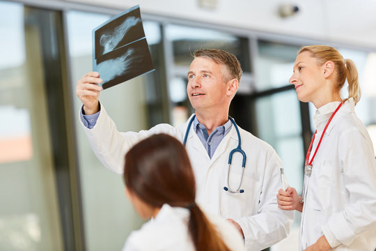 Oberarzt und Team besprechen Röntgenbild