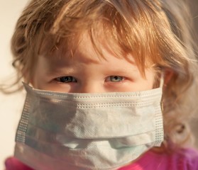 A kid in  A MEDICAL MASK
