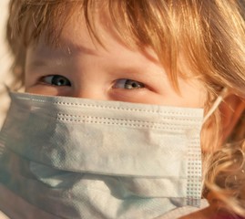 A kid in  A MEDICAL MASK