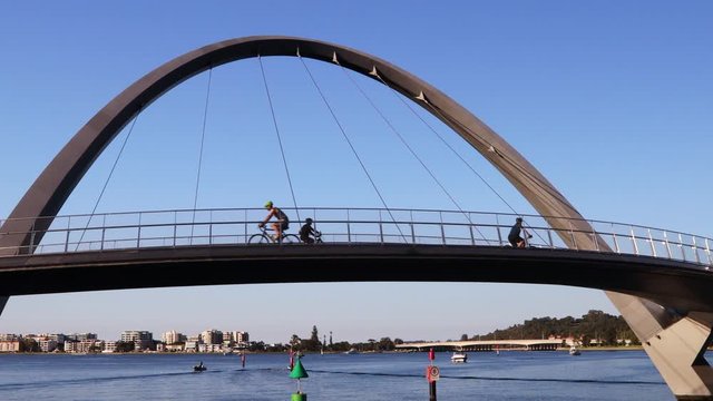 Cyclist are exercising during beautiful morning blue sky sunrise on iconic Elizabeth Quay Marina Bridge, Swan River Perth, City CBD one of the new tourist attraction in Western Australia.