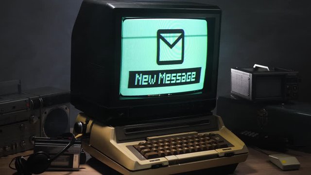 Vintage computer setup from the 70s 80s receiving "new message" alert  on the monitor. Old technology concept...