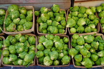 Containers of fresh organic green Brussels sprouts at the farmers market