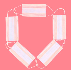 Frame made with many medical masks on a pink background, concept of protection against flu, viruses...
