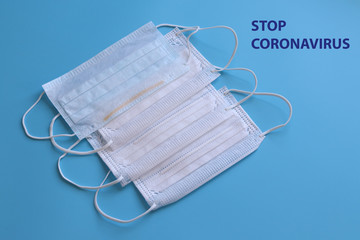 Medical disposable masks on a blue background. The inscription Stop Coronavirus
