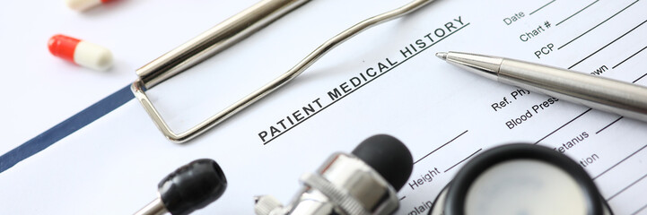 Medical instruments and pills lying at patient history list