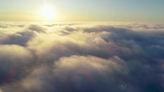 Flying over the evening timelapse clouds with the late sun. Seamlessly looped animation. Flight through moving cloudscape with beautiful sun rays. Perfect for cinema, background,