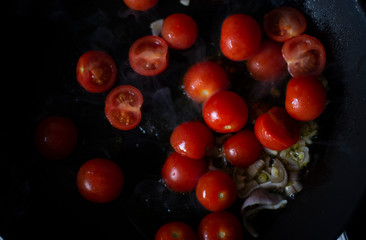 pezzi di pomodori datterino e scalogno tritato fritto in padella 