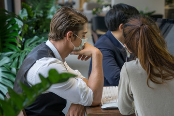 Business owner is handsome, wearing a surgical mask, thinking of planning and solving business...