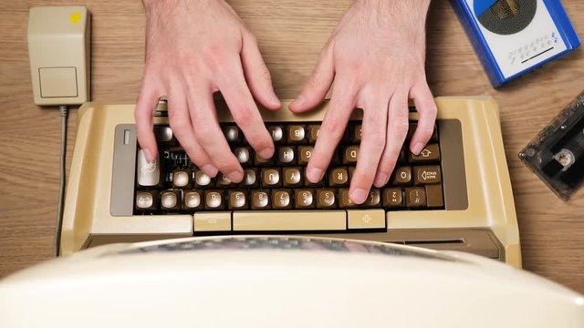 View from above of hands typing on an old vintage keyboard and using a retro mouse from 80s computer. Old technology concept.