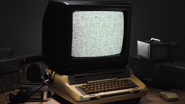 Zooming out of a vintage style monitor from 70s 80s showing a screen of static noise. Old technology concept ...