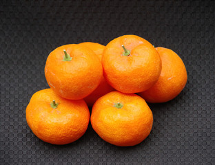 Small pile of six fresh organic tangerines on black background
