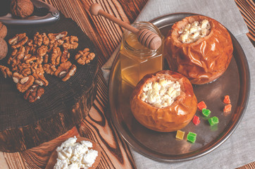 healthy food. Baked apples with cottage cheese and nuts lie in a black baking dish on a wooden table