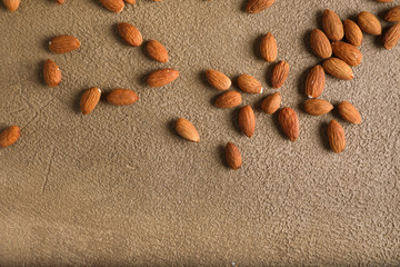 Almonds on a beige textured concrete background. Place for text. Aesthetic photography.
