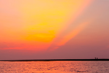 boy and girl are running on the beach after sunset