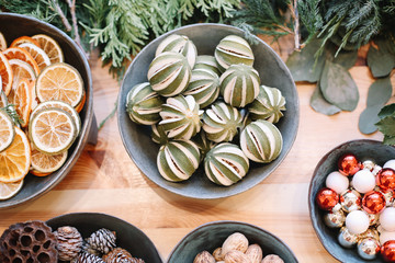 Base for Christmas wreath. Christmas decorations. Florist making Christmas wreath. View of female hands make a wreath. Decorations for wreath. Oranges, flowers red berries, wooden stars.