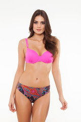 Obraz premium beautiful girl posing in stylish detailed pink bikini on white background.