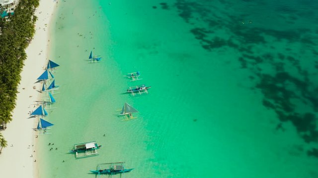 Tropical white sand beach with sailing yachts, hotels near the blue lagoon and corall reef. aerial view, Boracay, Philippines. Seascape with beach on tropical island. Summer and travel vacation
