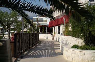 A footpath fenced with a wooden fence on one side and the stone foundation of a white building on the other