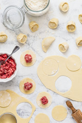 Cooking homemade meat dumplings. Traditional russian pelmeni or ravioli with meat on marble background. Culinary concept. Top view