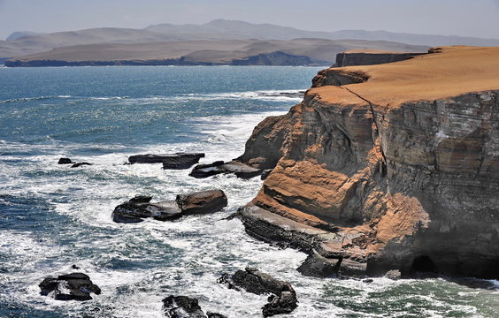 The waves of the Pacific Ocean wash the rocky shore. Peninsula Paracas. Peru.