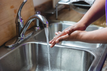 Black man washing hands in sink