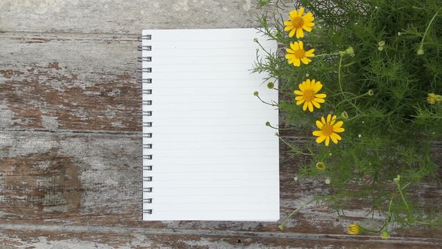 Notepad with empty page put on wooden background with flower, Gardening and Flower bed design concept.