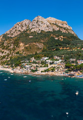 Obraz premium Aerial view of coastline of the village of Nerano. Private and wild beaches of Italy. Turquoise, blue surface of the water. Vacation and travel concept. Boats in bay. Copy space. Vertical photo