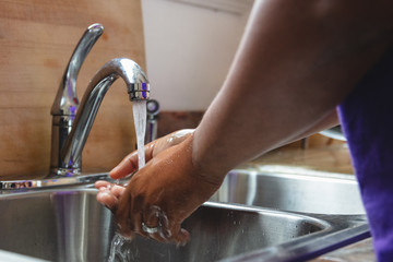 Black man washing hands in sink