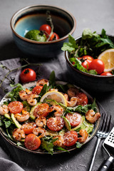 Salad with fried shrimp, tomatoes, avocado and arugula