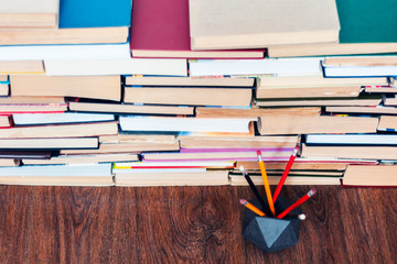 Pencils in holder and stack of books, school background for education learning concept.