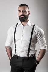 Uomo con barba camicia bianca e bretelle nere, isolato su sfondo bianco