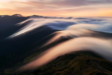 Washable wall murals Morning with fog Amazing flowing morning fog in spring mountains blurred from long exposure. Beautiful sunrise on background. Landscape photography