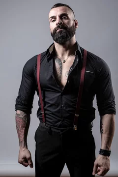 Ragazzo barbuto con Tatuaggi in tutto il corpo, vestito con camicia nera e  bretelle rosse, isolato su sfondo grigio Photos | Adobe Stock