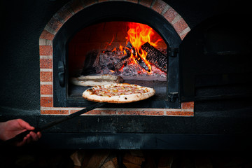 Cook makes pizza in the oven. - 331021261
