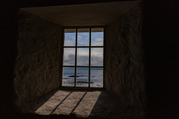 Fototapeta na wymiar Beautiful sea view behind old church window
