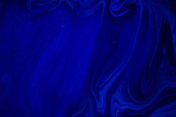 Fluid art texture. Backdrop with abstract swirling paint effect. Liquid acrylic picture that flows and splashes. Classic blue color of the year 2020. Blue, black and white overflowing colors