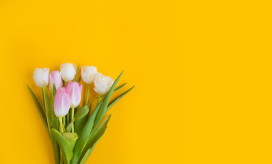 Pink tulips on the yellow background. Flat lay, top view. Valentines background.