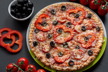 Pizza with olives, tomatoes, ham. Still-life. Assorted pizza