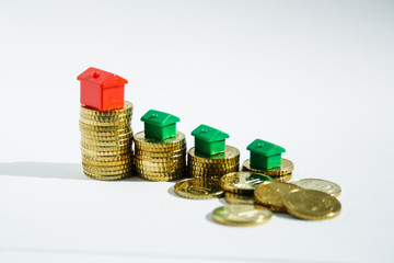 stacks of gold coins and red and green houses