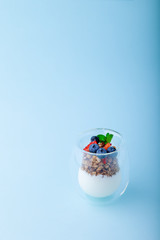 Obraz na płótnie Canvas White yogurt and granola with fresh strawberries, blueberries, mint in glass
