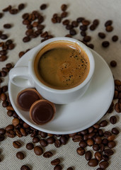 A cup of coffee for breakfast. Coffee beans. Espresso in a white cup.