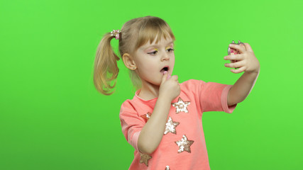 Caucasian girl on chroma key background applying red lipstick. Cosmetics, makeup